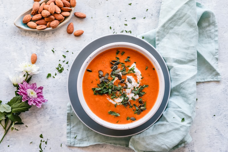 Steaming bowl of vegetable soup with herbs